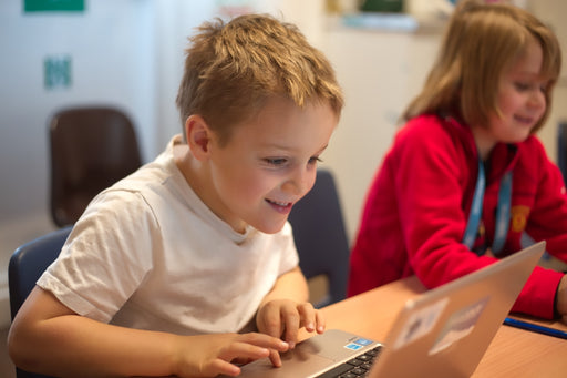 Boy smiling at laptop computer