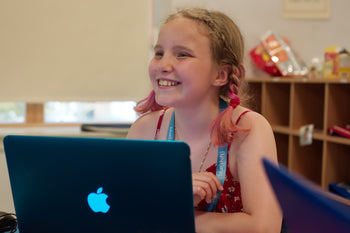 Girl smiling at laptop computer